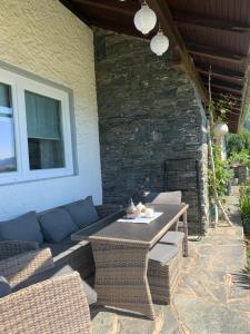 eine Terrasse mit einem Tisch und Korbstühlen in der Unterkunft Ferienwohnung KaRo in Bodensdorf