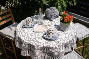 una mesa con un mantel con platos y tazas en Szürke Vendégház Balatonkenesén en Balatonkenese