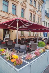 ein Tisch mit Blumen und einem Regenschirm darauf in der Unterkunft Hotel Blauer Engel in Aue