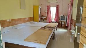Postel nebo postele na pokoji v ubytování Jogalekar Cottage Alibaug