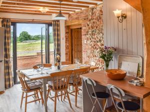 a dining room with wooden tables and chairs at Oak Barn in Felbrigg