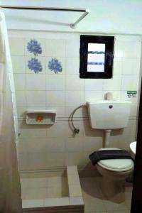 a bathroom with a toilet and a window at Creta Star Apartments in Agia Galini