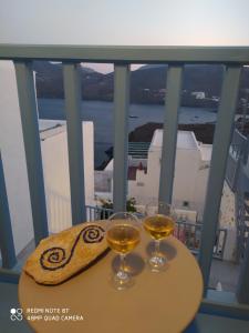 two glasses of wine on a table on a balcony at Aiolos TRADITIONAL HOUSE IN ASTYPALAIA in Astypalaia