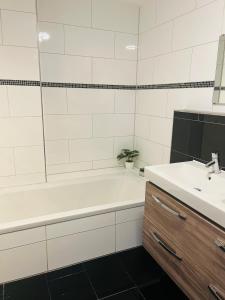 a bathroom with a white tub and a sink at Bodensee Life in Friedrichshafen