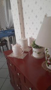 un comò rosso con una lampada e vasi sopra di Hotel Villa Mon Reve a Rimini