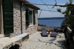 - une terrasse avec des chaises, une table et de l'eau dans l'établissement Eco Residence Rokotovi, à Stari Grad