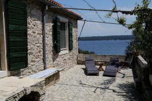 un patio con sillas, una mesa y agua en Eco Residence Rokotovi, en Stari Grad