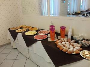 Hotel Villa Mon Reve في ريميني: طاولة مليئة بأطباق الطعام والمشروبات