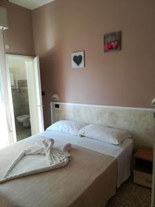 a bedroom with a bed with two hearts on the wall at Hotel Villa Mon Reve in Rimini