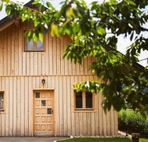 un edificio de madera con 2 ventanas y una puerta en Family Bungalow Glamping Laško, en Laško