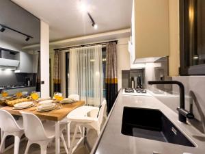 een keuken met een houten tafel en witte stoelen bij Luxurious Villa w Pool Sauna Patio in Fethiye in Fethiye