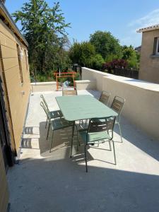 une table et des chaises vertes sur la terrasse dans l'établissement La maison Mousseaux, Centre ville 2 chambres, à Châteauroux