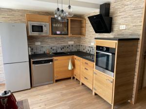 - une cuisine avec des placards en bois et un réfrigérateur blanc dans l'établissement La maison Mousseaux, Centre ville 2 chambres, à Châteauroux