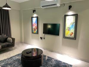 - un salon avec un canapé et une télévision murale dans l'établissement Gulshan Stylish 3 bedroom Luxury Apartment in Prime location, à Dhaka