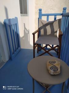 a chair and a table with a pillow on a porch at Aiolos TRADITIONAL HOUSE IN ASTYPALAIA in Astypalaia