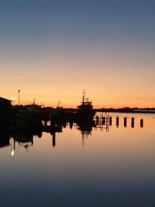 een boot in het water bij zonsondergang bij Bamboo Motor Inn in Lakes Entrance