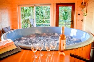 a hot tub with wine glasses on a table at Ośrodek Wypoczynkowy Bernadetta in Murzasichle