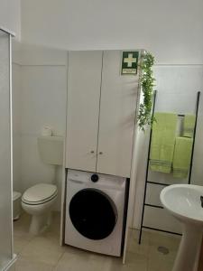 a small bathroom with a toilet and a sink at Sweet Home - Praia das Rocas in Castanheira de Pêra