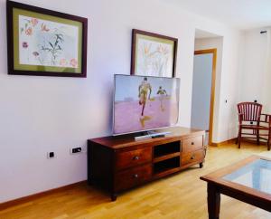 a living room with a flat screen tv on a dresser at El Mirador de Lobos Fuerteventura in Corralejo