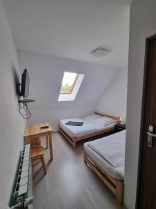 a bedroom with two beds and a table and a window at Willa Gazda in Sromowce Niżne