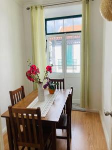 - une table en bois avec des fleurs dans une chambre avec une fenêtre dans l'établissement Downtown Apartment, à Horta