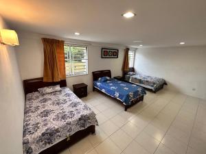 a bedroom with two beds and a window at Terbilang Homestay in Butterworth