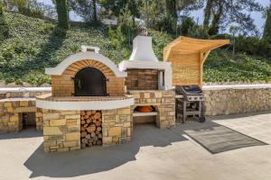 a brick oven with a grill in a yard at Aegean View Estate - Villa in Faliraki