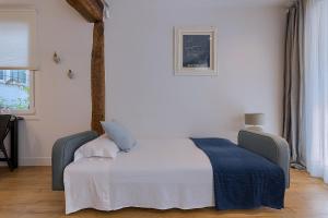 una camera da letto con un letto con una coperta blu sopra di Moderno y Lujoso en el Historico Casco Viejo a Bilbao