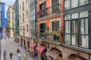 a group of people walking down a street with buildings at Moderno y Lujoso en el Historico Casco Viejo in Bilbao