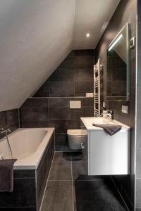ein Badezimmer mit einer Badewanne, einem Waschbecken und einem WC in der Unterkunft Het Heerengoedt in Ambt Delden