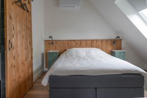 een slaapkamer met een bed met een houten hoofdeinde bij Het Heerengoedt in Ambt Delden