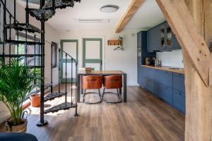 a kitchen with blue cabinets and a wooden floor at Het Heerengoedt in Ambt Delden +18 photos