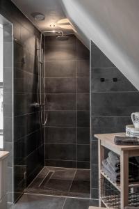 a bathroom with a shower with black tiles at Het Heerengoedt in Ambt Delden