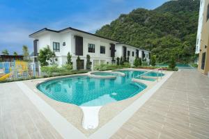 een zwembad voor een huis bij Unique Boho Style Condo with NETFLIX for up to 5PAX - Enjoy Mountain View while swimming at the Infinity Pool & Natural Hotspring Pool, 2mins walk to the Lost World of Tambun, Water Themepark at IPOH in Ipoh