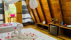 una camera con un letto con un cigno sopra di Habarana Tree House Ambasewana Resort a Habarana
