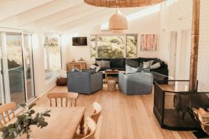 ein Wohnzimmer mit Couch und Tisch in der Unterkunft Saltair Freycinet in Dolphin Sands