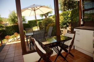 een tafel en stoelen met een parasol op een patio bij 2 HABIT, SALA, TERRAZA, JARDIN, PARKING GRATiS in Zumaia