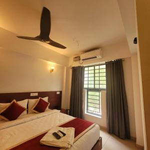 1 dormitorio con 2 camas y ventilador de techo en Four Squares Inn, Technopark phase 3, en Trivandrum