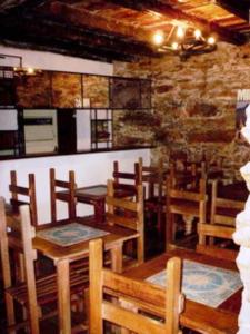 un restaurante con mesas y sillas de madera y una pared de ladrillo en Pousada Vila Rica, en Ouro Preto