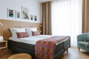 um quarto de hotel com uma cama e uma cadeira em Old Hapsal Hotel em Haapsalu