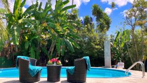 a resort pool with chairs and a swimming pool at Swiss Chalet Garden, Pool Resort in Krabi