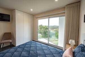 um quarto com uma cama e uma grande janela em Casa da Bina em Paredes