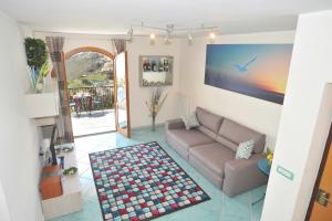 uma sala de estar com um sofá e um tapete em Colpo d Ali - Amazing view and Jacuzzi in Ravello em Ravello