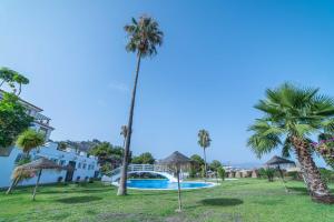 - Vistas a un complejo con piscina y palmeras en Alma de Marina en La Herradura