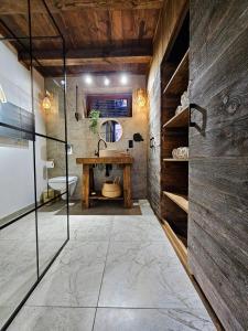 a bathroom with a sink and a wooden wall at Stodoła między lasami - Roztocze in Górniki +73 photos