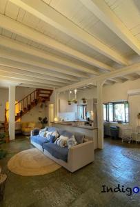 una gran sala de estar con un sofá azul en una habitación en Poseidonia The Greek Lifestyle, en Lambírion