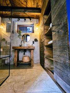 a bathroom with a sink and a wooden wall at Stodoła między lasami - Roztocze in Górniki