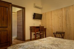 sypialnia z łóżkiem, biurkiem i telewizorem w obiekcie L'Antico Vigneto w mieście Marino
