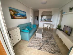 un soggiorno con divano blu e tavolo di Pino Parquemar a La Mata