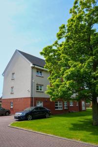 a black car parked in front of a house at Modern Apartment Ayr Town Centre in Prestwick